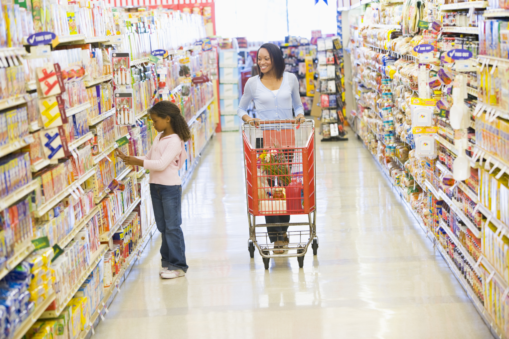 A mother and daughter shopping in a grocery store